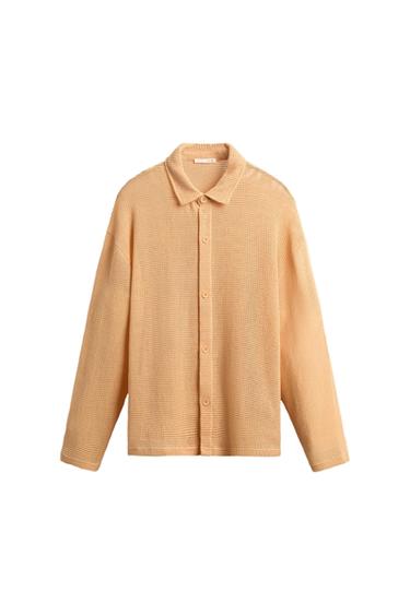 Beige knit shirt with front buttons and classic collar, on a white background.