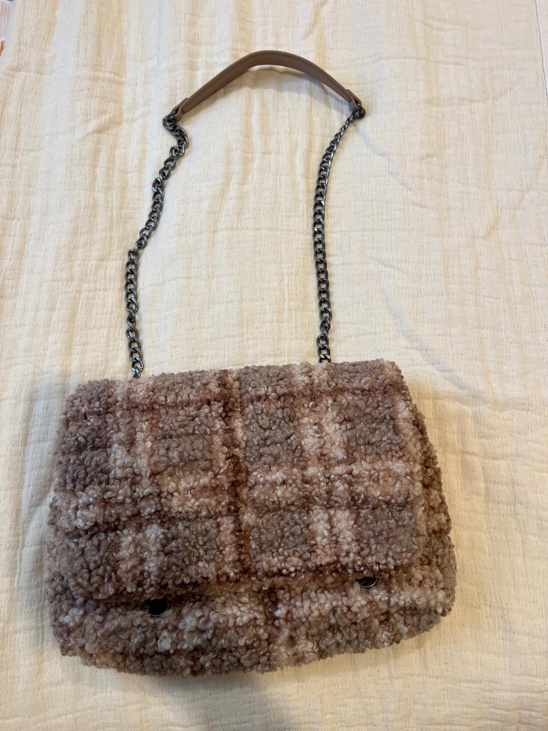 Wool handbag with brown and beige check design, metallic chain and brown handle on a light background.