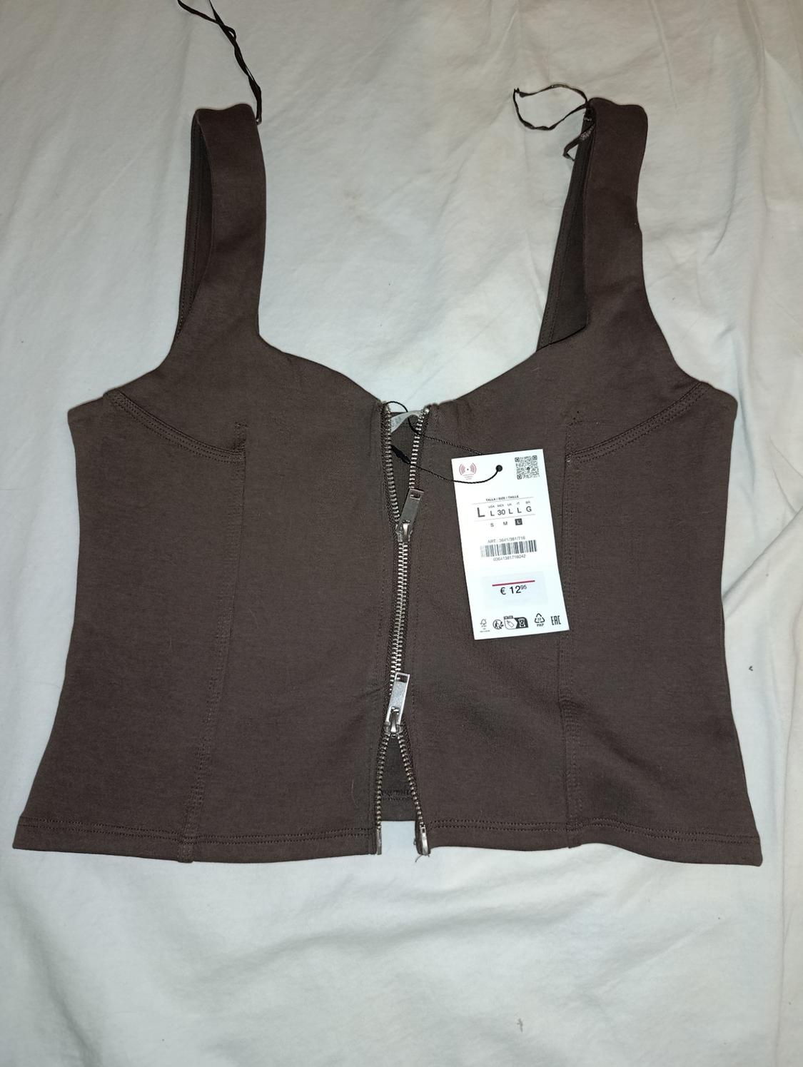 Brown zip-front camisole cropped top with label featuring text L L 30 L L G S M L €12.95, on white fabric.