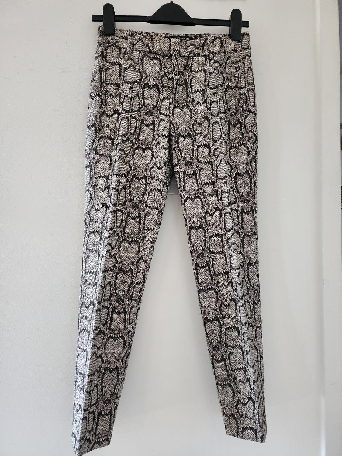 Front view of snake print pants with a straight cut and side pockets.