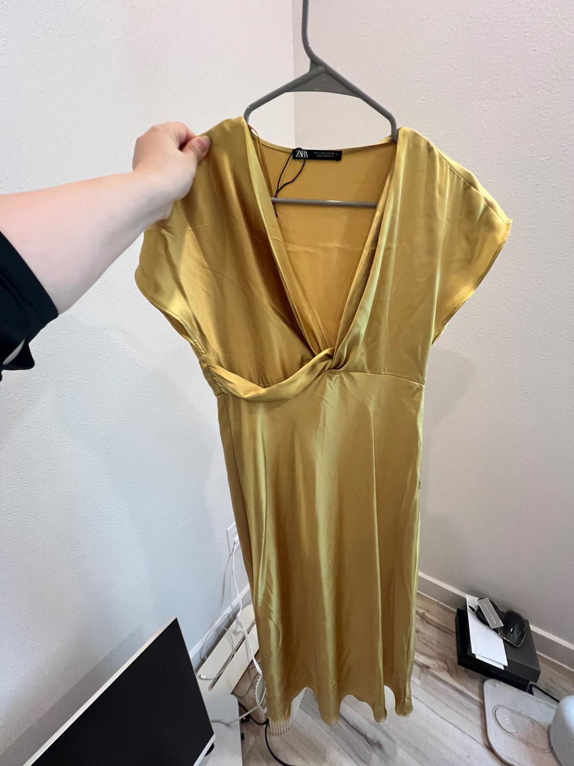 Front view of yellow dress with V-neck. Sleeveless and straight hem.