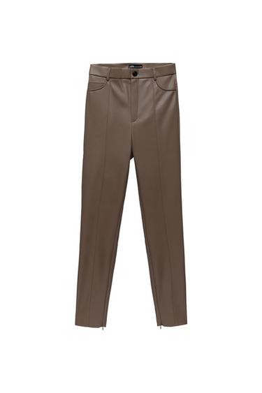 Brown trousers with front seams, pockets, button fastening, belt loops, and zips at the hem on a white background.