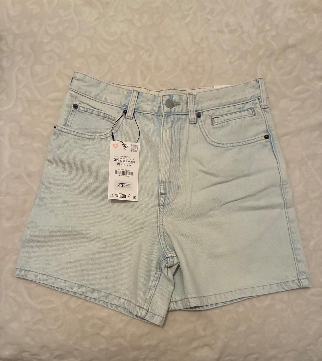 Light blue denim shorts with a price tag of €39.99. Fabric background with a subtle pattern.