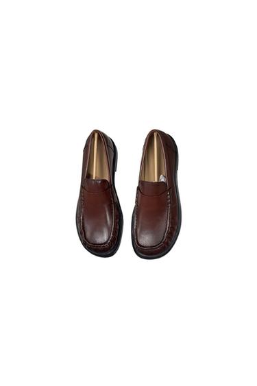 Two brown loafers with a classic design, visible stitching, and a dark sole, isolated on a white background.