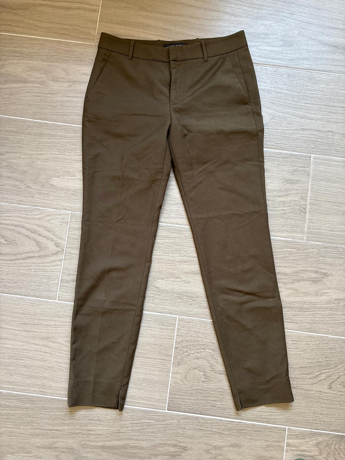 Front view of brown trousers with side pockets and belt loops.