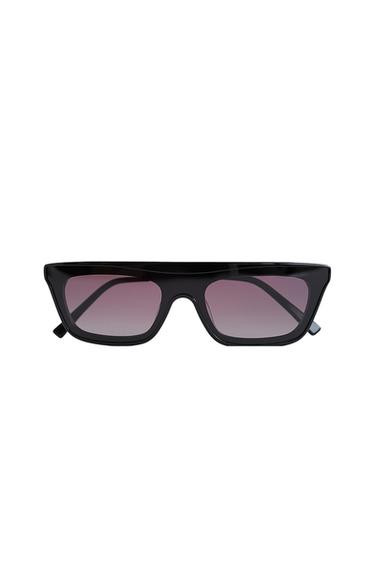 Black sunglasses with thick frames, a flat top and gradient lenses on a white background.
