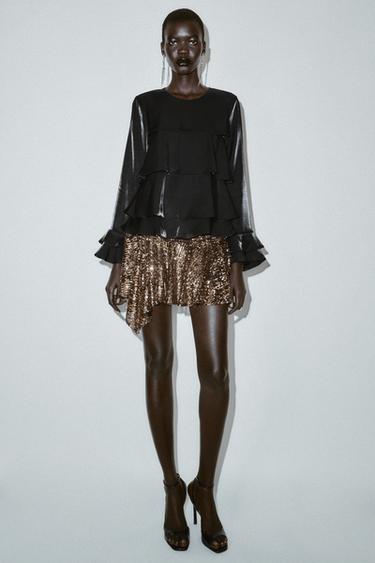 BRUSA AMB VOLANTS I TEIXIT BRILLANT - Negre de Zara