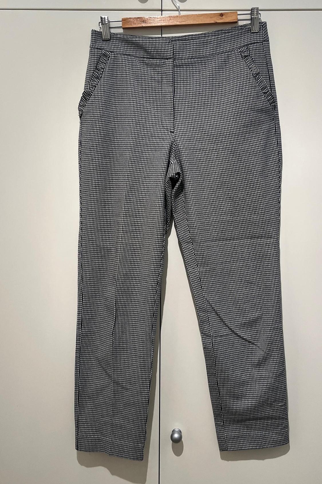 Front view of black and white checked trousers with side pockets.