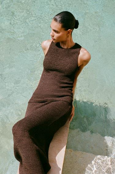 Komplet dlouhých pletených přiléhavých šatů čokoládové barvy, bez rukávů a s kulatým výstřihem.