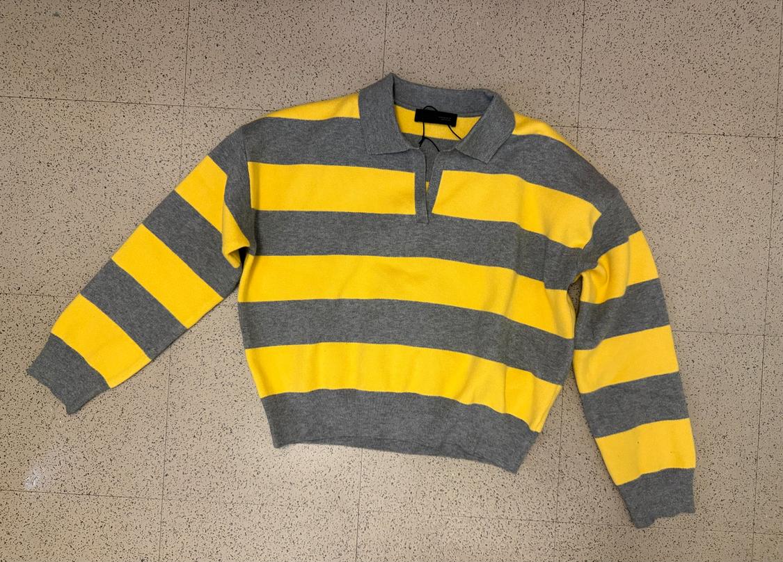 Yellow and gray horizontal striped sweater on a light background. Long-sleeved design with a polo neck.