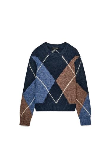 Front view of a navy knitted jumper with a round neck and long sleeves. Diamond print in blue and brown. Ribbed trims.