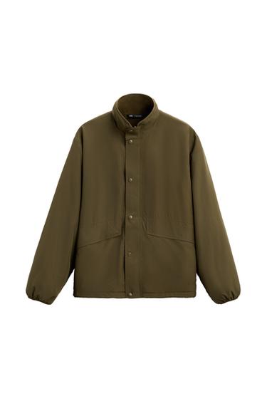 Front view of an olive green jacket with a high neck and press-stud fastening.