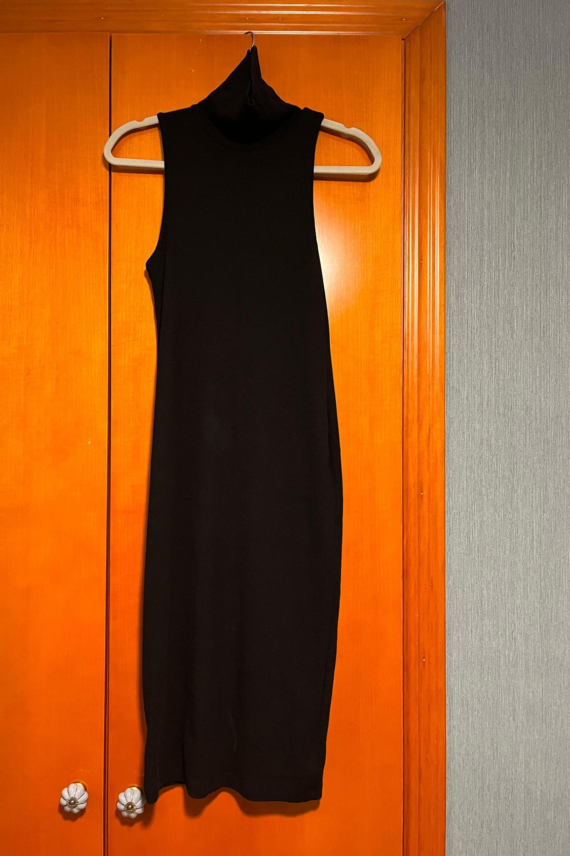 Front view of a black sleeveless polo neck dress.