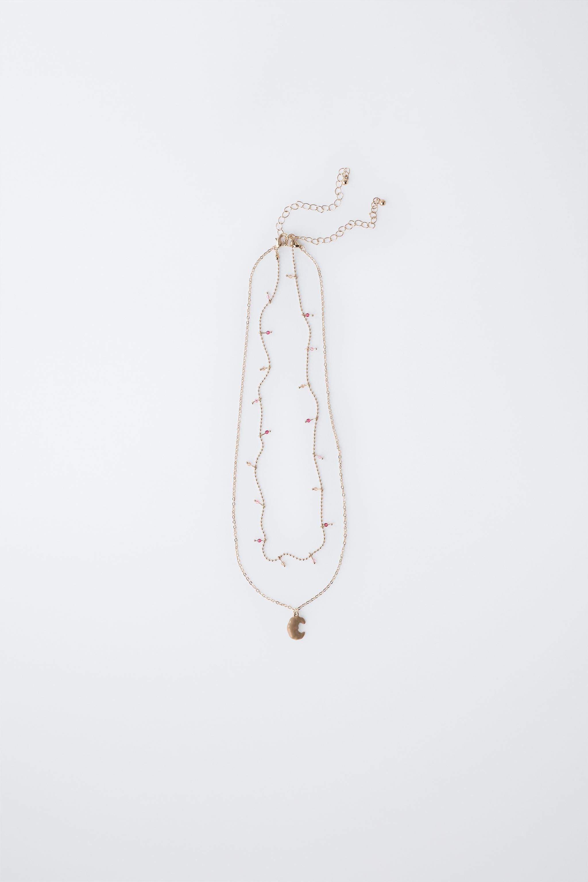 LOT DE DEUX COLLIERS AVEC PENDENTIF CROISSANT