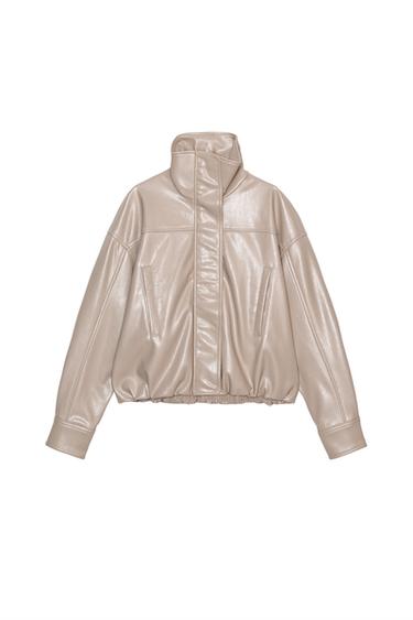 Front view of a beige jacket with a high neck, concealed fastening, and side pockets.