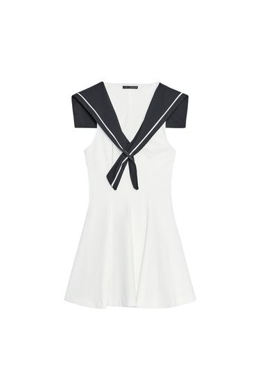 Front view of white dress with black sailor-style collar and white trim.