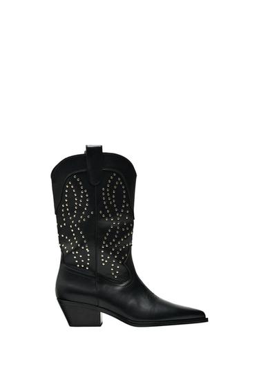 Side view of a black boot with a low heel and decorative studs on the vamp.