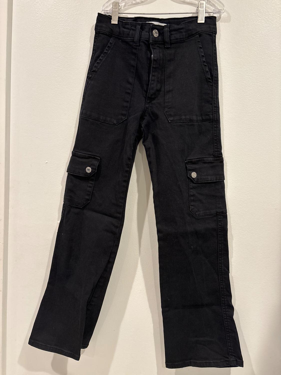 Front view of black pants with side pockets and metal buttons.