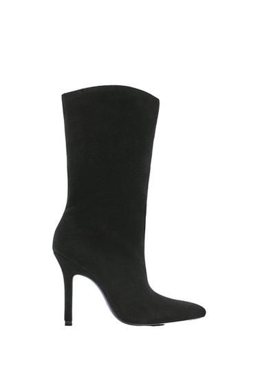 Black high-heeled boot with a thin heel and pointed toe, side view on a white background. Elegant and minimalist design.
