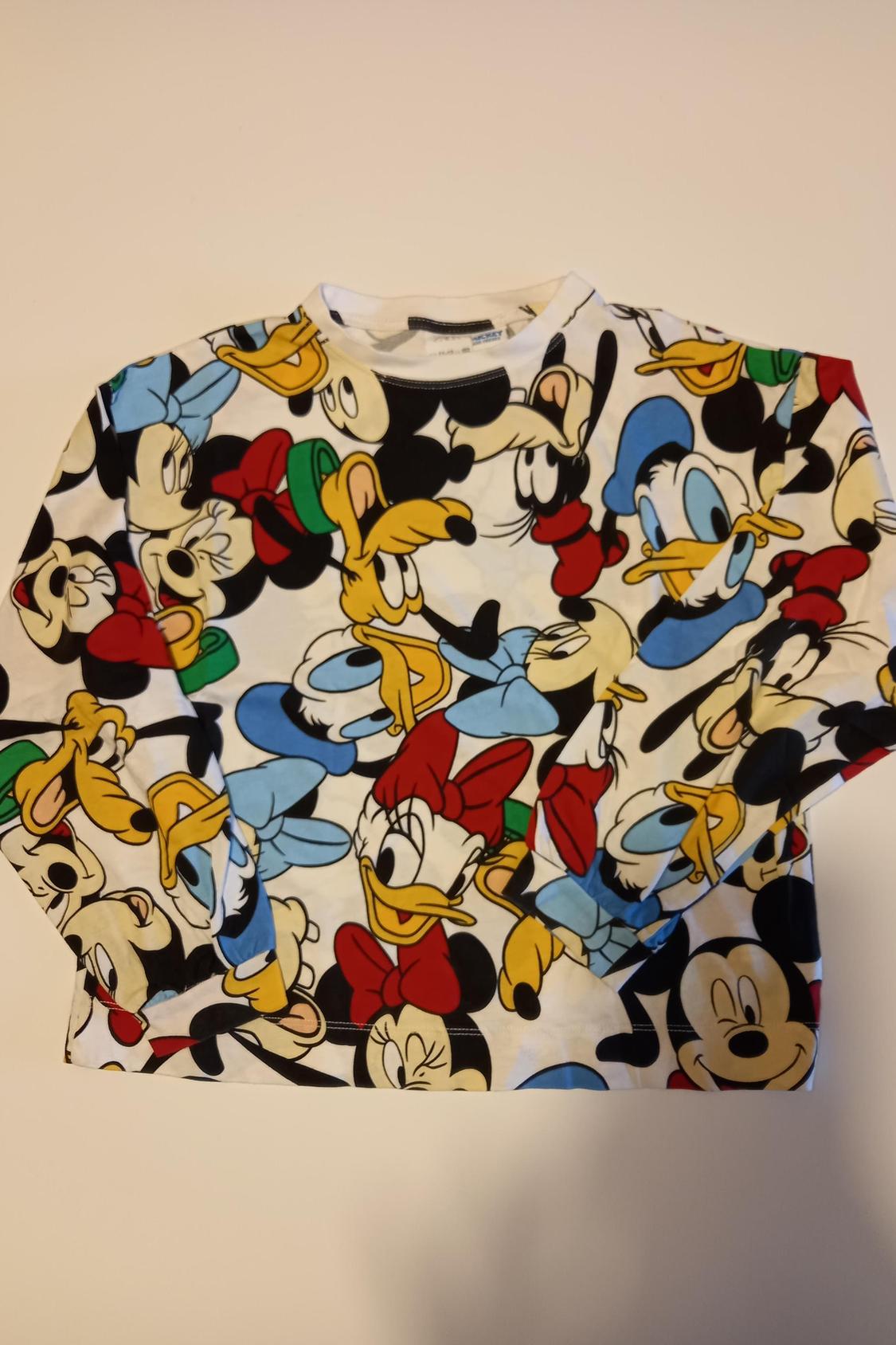 Front view of a t-shirt with a Disney character print, including Mickey Mouse, Donald Duck and more.