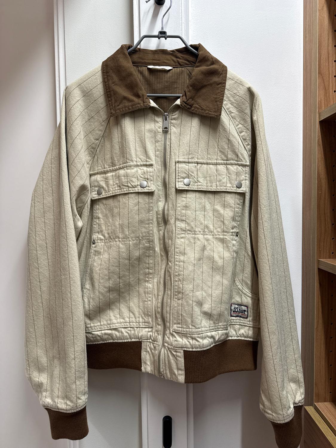 Beige jacket with fine stripes, brown collar and cuffs, zip fastening, and buttoned pockets. "50 Star" label on the side.