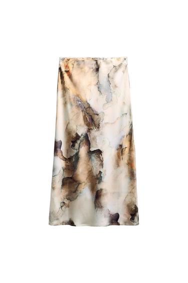 Midi skirt with an abstract print in brown and beige tones on a white background, hanging against a white background.