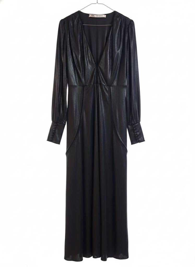 Long black sparkly dress, with long sleeves and a deep V-neckline, hanging on a white hanger against a white background.