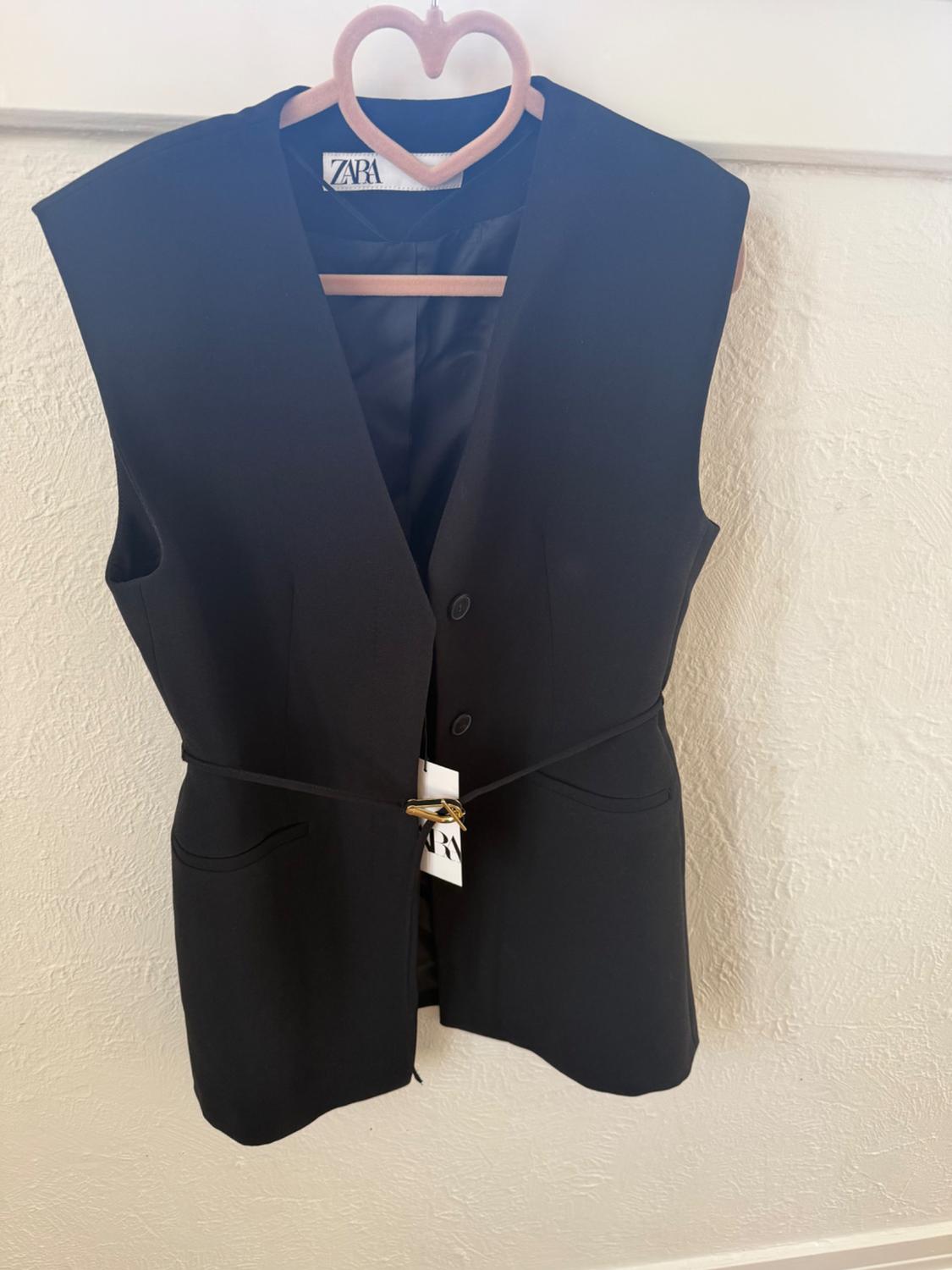 Front view of a black waistcoat with side pockets and button fastening.