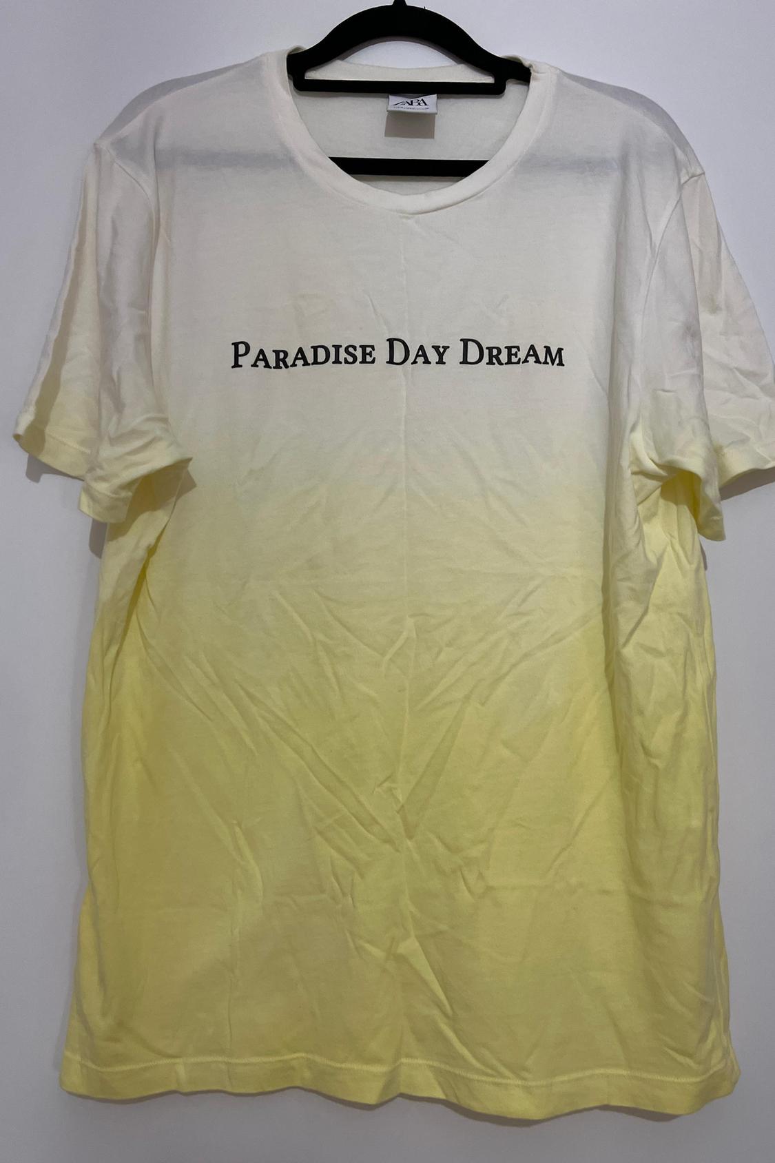 Front view of T-shirt with text 'Paradise Day Dream', gradient from white to yellow.