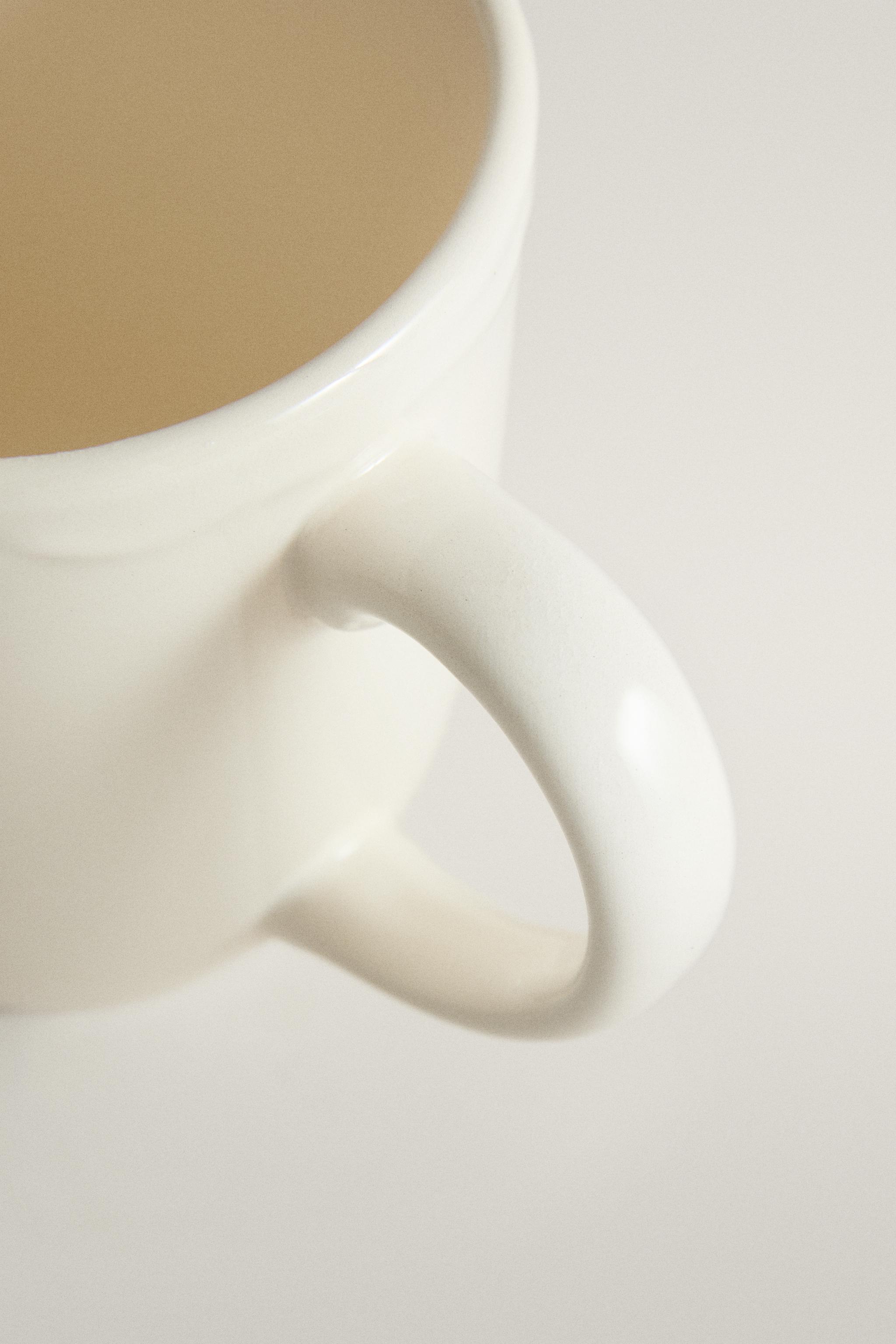 EARTHENWARE MUG WITH A RAISED-DESIGN EDGE