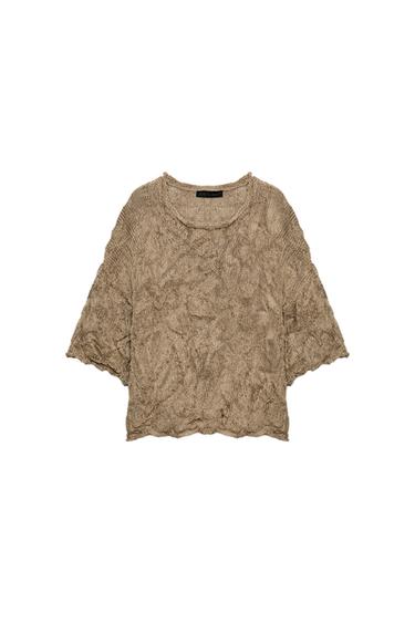 Front view of a toasted knitted jumper with a crinkled effect, a round neck, and wide, short sleeves.