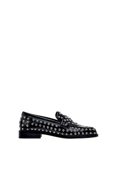 Black loafer with silver metal studs, side view.