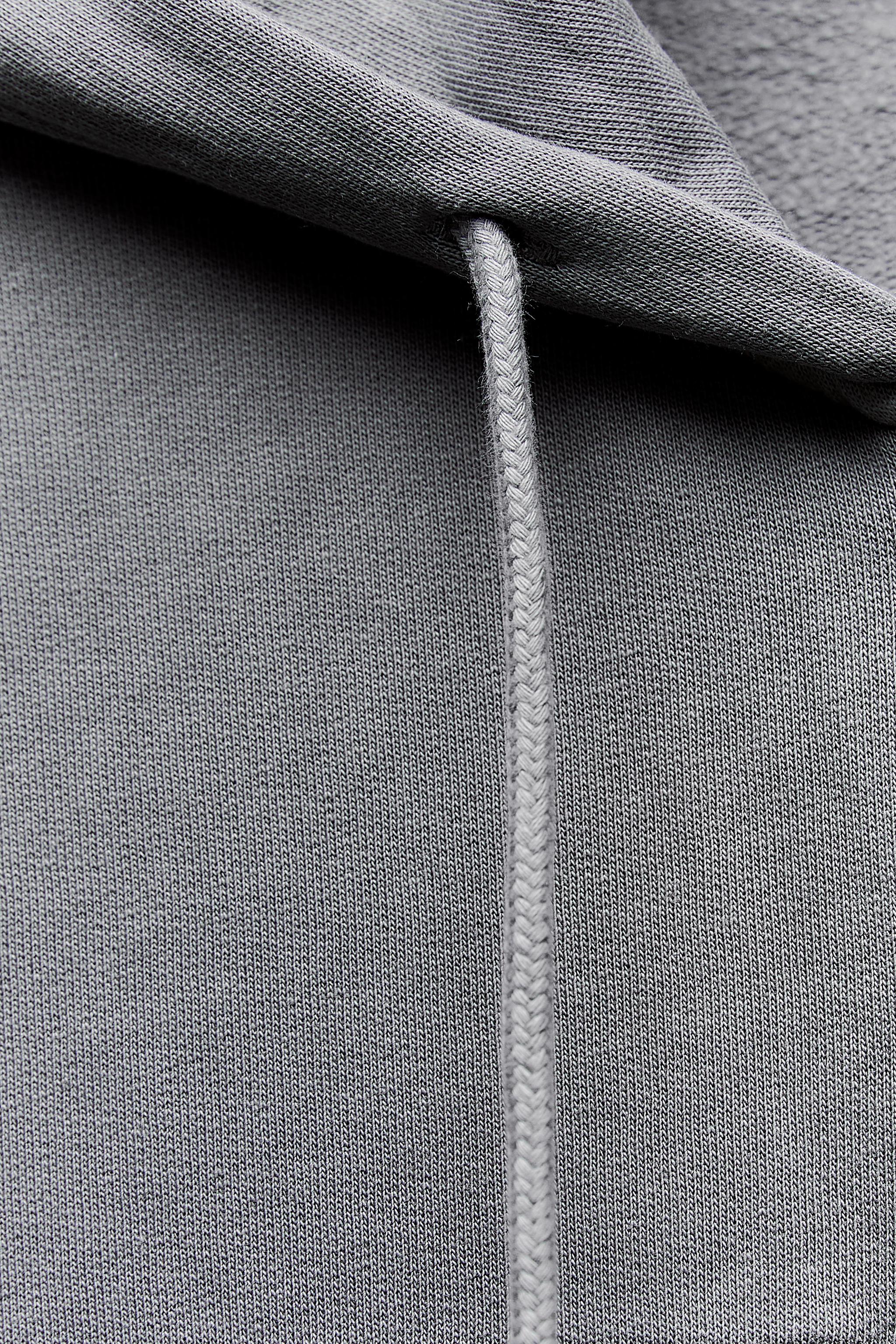 Sweatshirt with adjustable drawstring hood. Long sleeves with elastic  cuffs. Front pockets. Front metal zip closure.