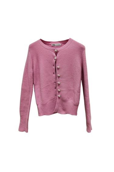Front view of pink cardigan with decorative buttons and long sleeves.