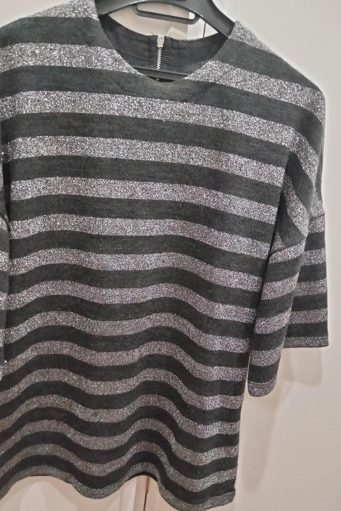 Front view of a grey and silver striped blouse with back fastening.