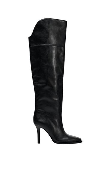 Black high heel boot, with an elegant design and smooth texture, on a white background.