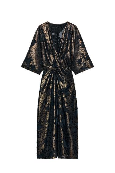 Front view of black dress with gold floral print, crossover neckline, and wide three-quarter sleeves.