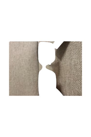 Close-up of textured beige fabric on a white background, forming negative space in the centre that outlines the letter K.