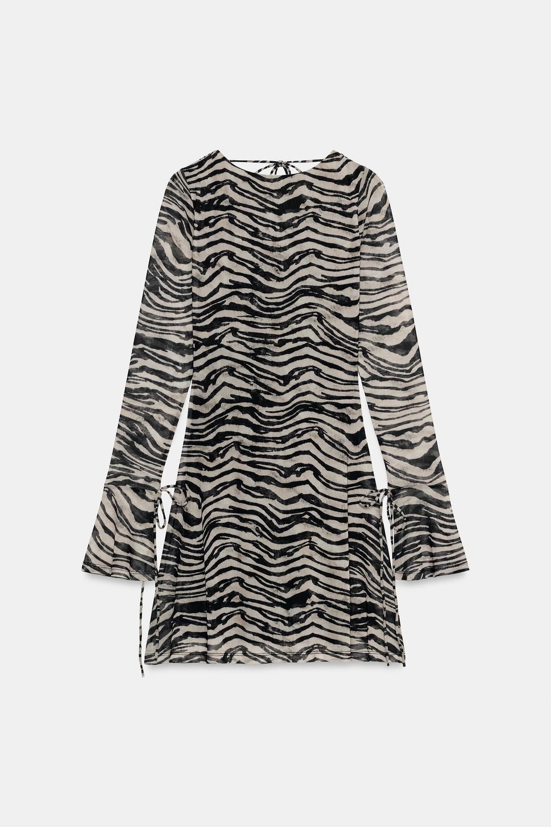 Front view of a short zebra print dress with a round neck, long flared sleeves and ribbon tie details on the cuffs and sides.