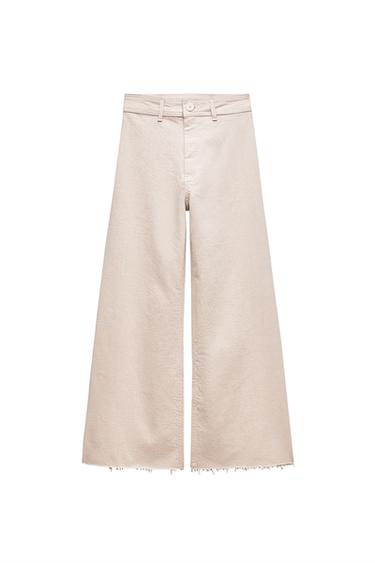 Front view of beige wide-leg trousers with waistband and frayed hem.
