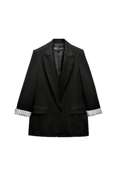 Front view of a black blazer with lapels and side pockets. Visible lining in the sleeves.