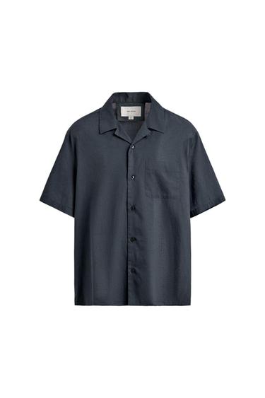 Short-sleeve shirt in dark gray with a lapel collar, front button closure, and chest pocket, shown against a white background.