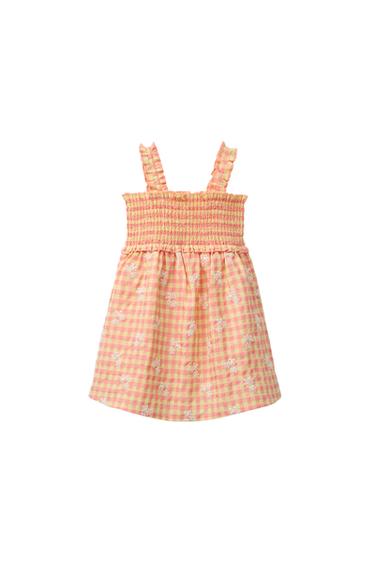 Front view of a pink and yellow gingham dress with straps and floral embroidery.