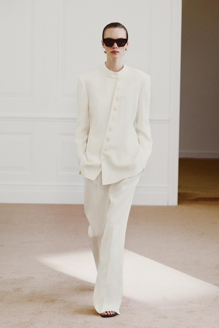 Komplet sako ve stylu raw se zk��en�m zap�n�n�m na knofl�ky a slad�n� rovn� kalhoty. Viditeln� p�edn� kapsy.