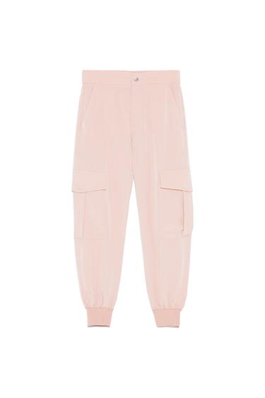 Light pink cargo trousers with a jogger design, side flap pockets, button waist and elasticated cuffs on a white background.
