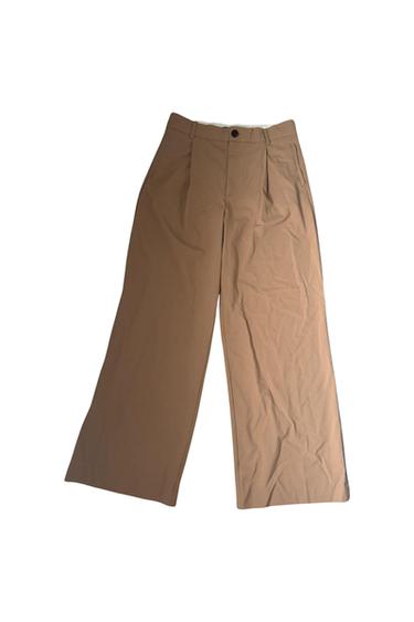 Front view of brown trousers with side pockets and a front button.