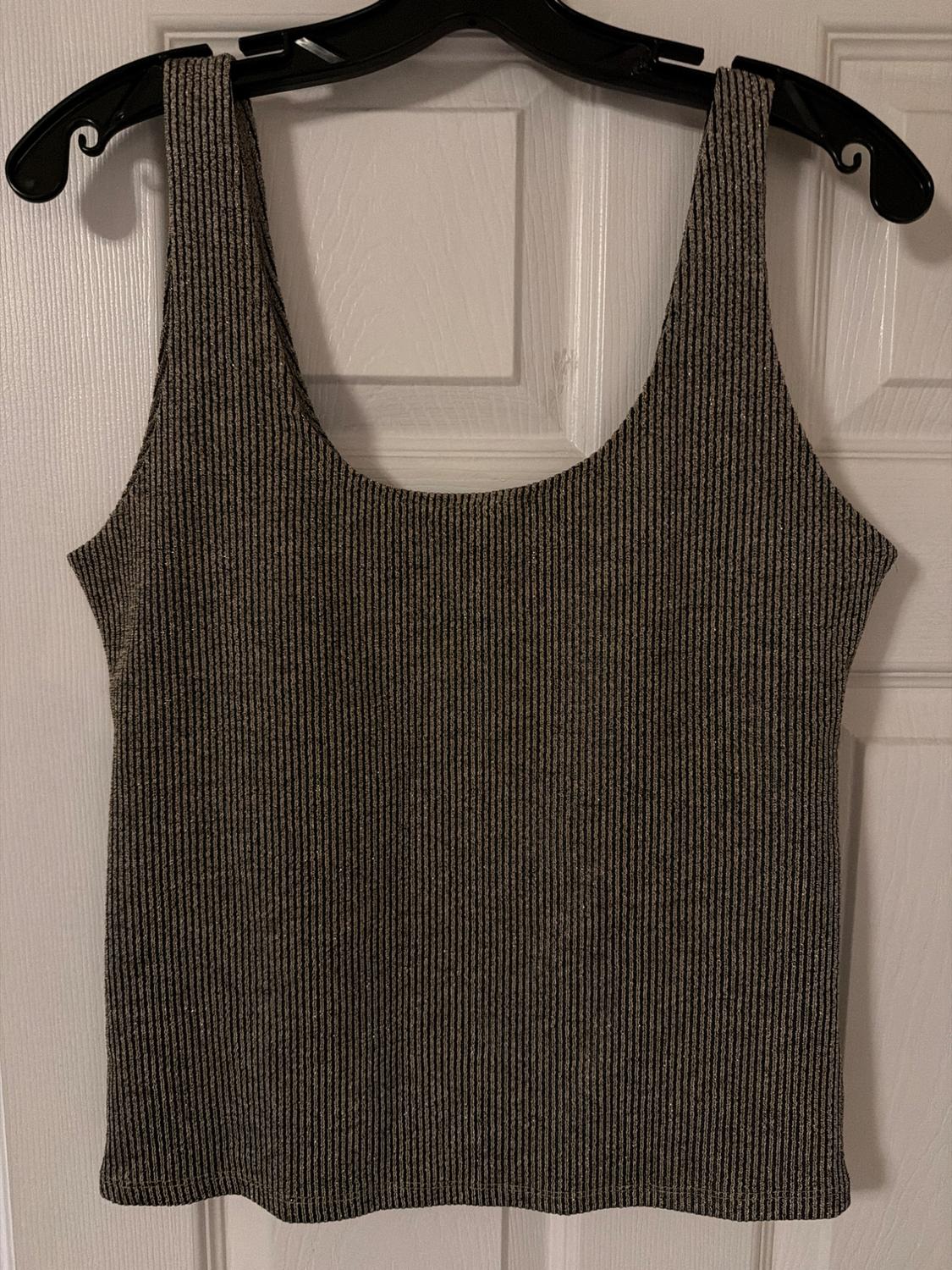 Wide-strap ribbed tank top with metallic thread, hanging on a black hanger in front of a white wooden door.