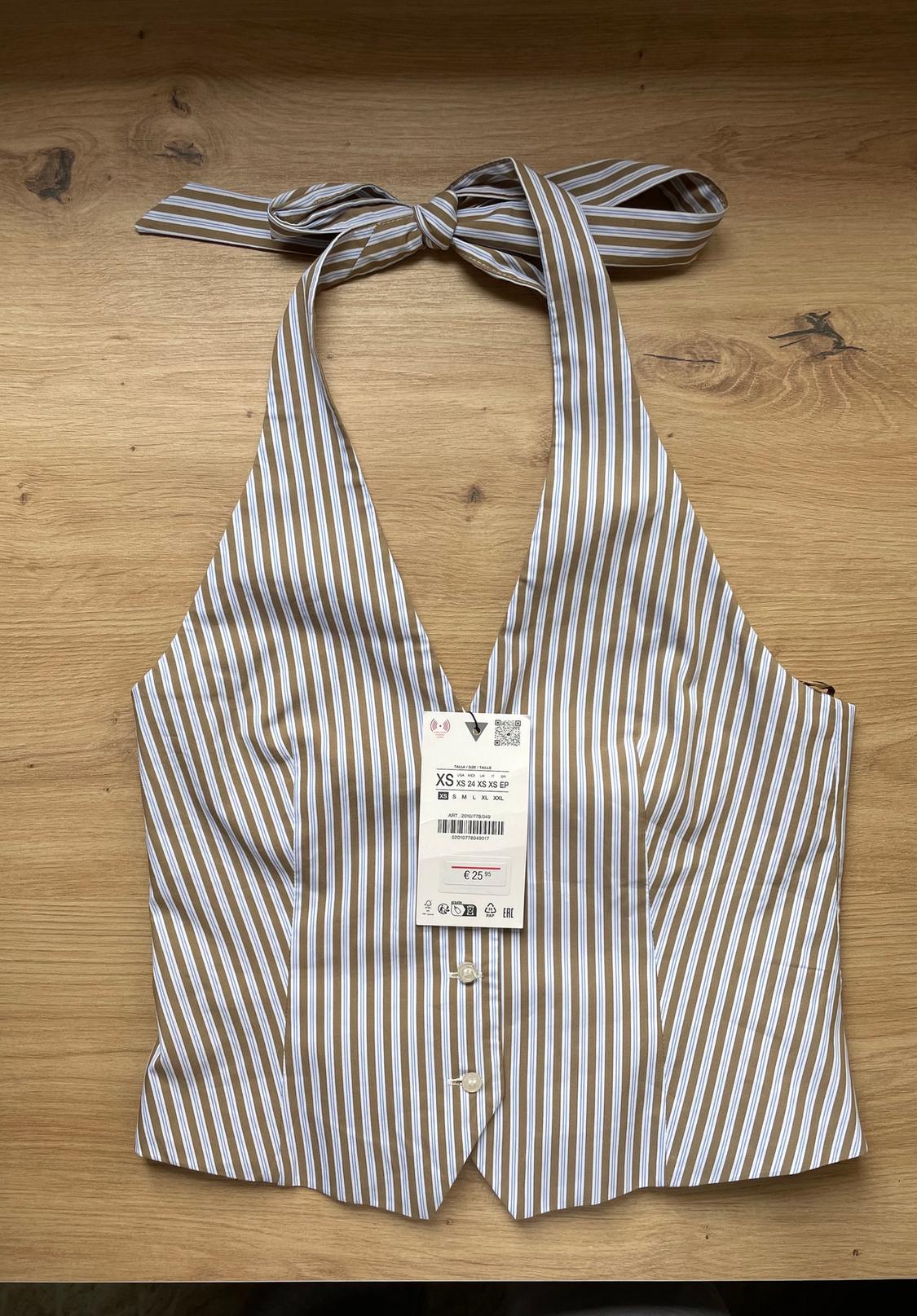 Brown and white striped halter-neck top with a price tag of €25.95 on a wooden surface.