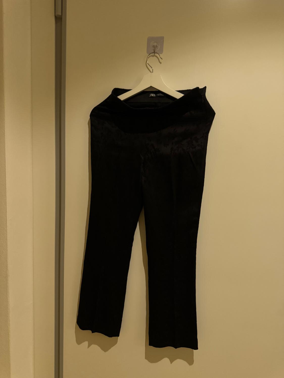 Front view of black trousers with a high waist and straight leg.