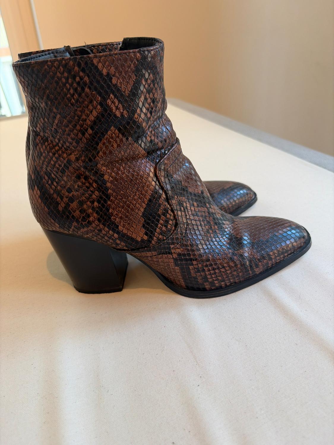 Μποτάκια με φαρδύ τακούνι και animal print φιδιού σε καφέ και μαύρους χρωματισμούς, πάνω σε ανοιχτόχρωμη βάση.